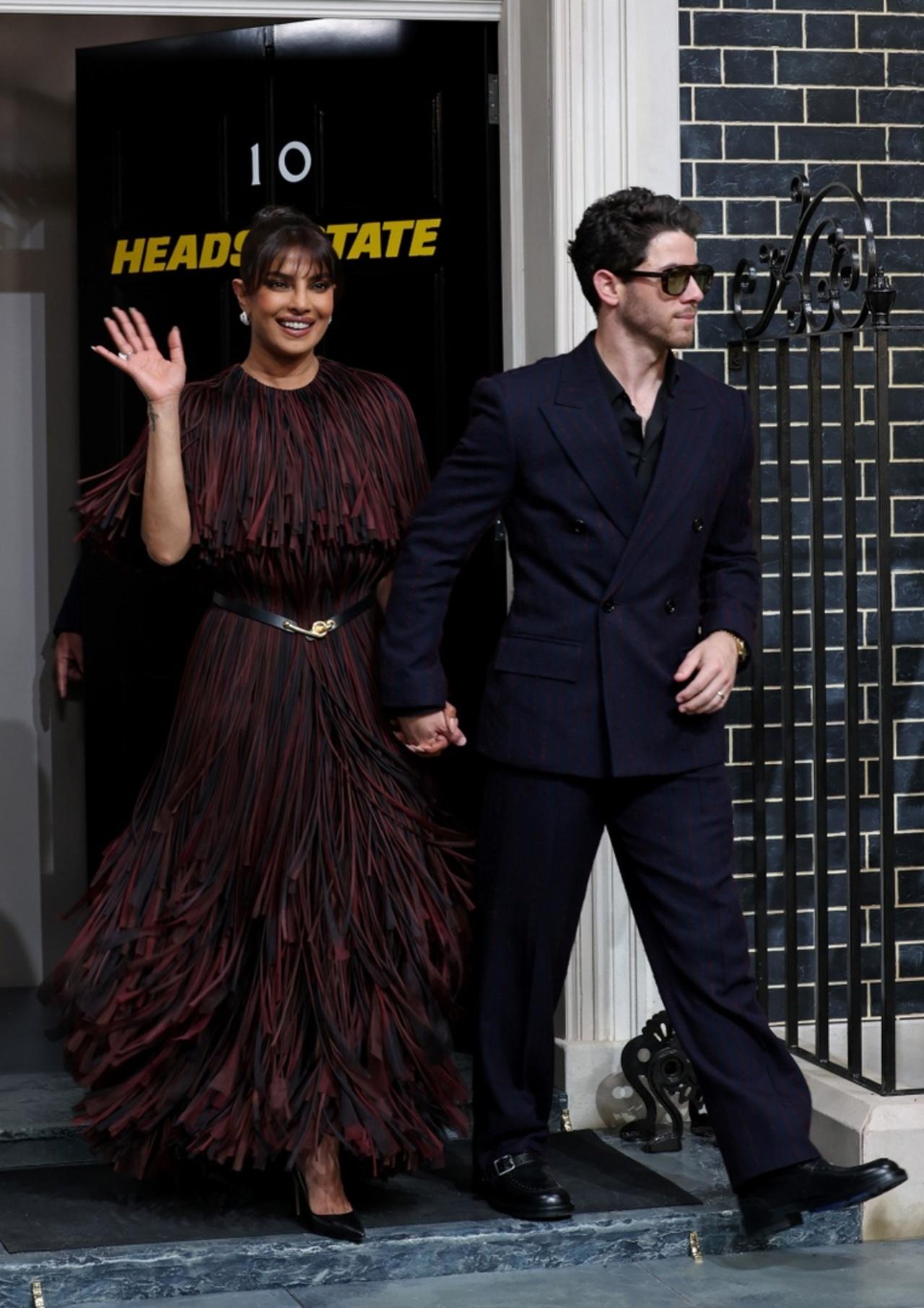 She completed the ensemble with a sleek updo and fringe bangs that framed her radiant smile, exuding effortless sophistication beside Nick Jonas in a sharp double-breasted suit